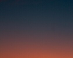 Crescent moon and fiery orange sunset horizon
