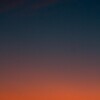 Crescent moon and fiery orange sunset horizon